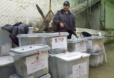 
A Palestinian police officer watches over ballot boxes at an election center in the West Bank town of Jenin on Tuesday. 
 (Associated Press / The Spokesman-Review)