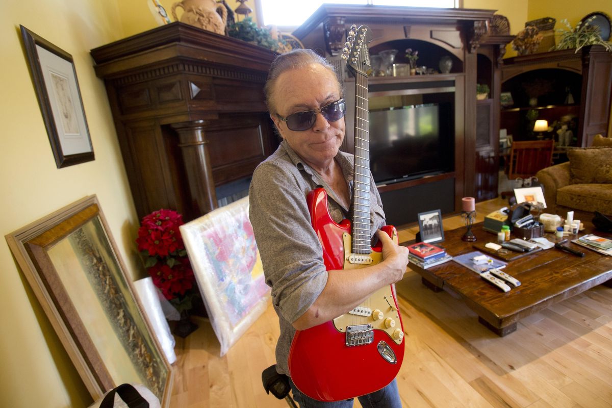 In this, Wednesday, July 22, 2015 photo, 1970s heartthrob David Cassidy holds one of his favorite guitars as he gives a tour of his five-bedroom Florida mansion in Fort Lauderdale, Fla. Cassidy, 65, was auctioning the waterfront home and all its furnishings Sept. 9 as part of bankruptcy and divorce proceedings. Cassidy has died, his publicist confirmed Tuesday, Nov. 21, 2017. (Wilfredo Lee / AP)