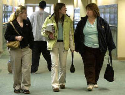 
Shiri Howell, 17, middle, and her mom Angie, right, discuss where they will meet when Howell is done with her classes while Katlyn Laughlin, 18, left, walks with Howell to her next class. 
 (Liz Kishimoto / The Spokesman-Review)