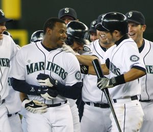 Seattle Mariners' Ken Griffey Jr., left, is mobbed by teammates including Ichiro Suzuki, right, after Griffey hit the  game-winning, RBI pinch-hit single in the ninth inning a baseball game against the Toronto Blue Jays, Thursday, May 20, 2010, in Seattle. Milton Bradley scored on the hit, which gave the Mariners a 4-3 win. (Ted Warren / Associated Press)