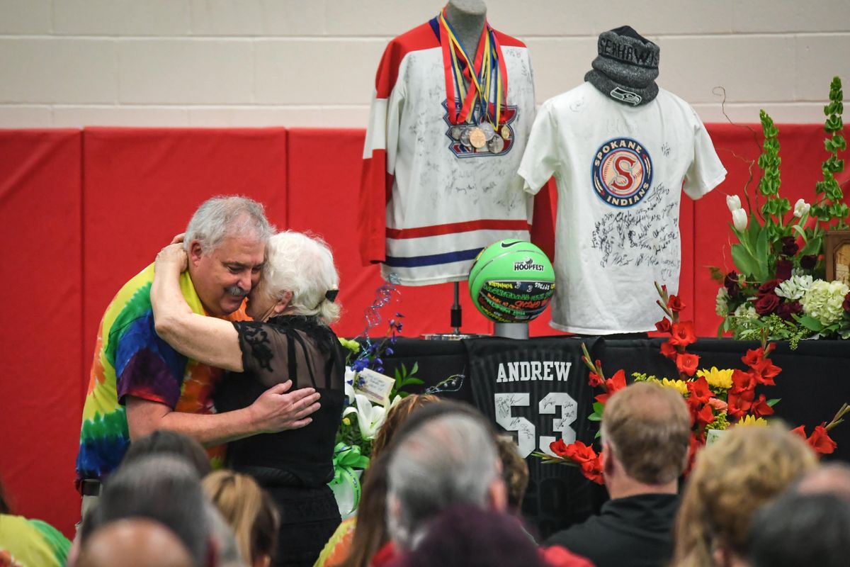 Rick Chase embraces Erika Vathis, mother of Andrew Vathis, after Chase delivered heart-felt memories at Andrew memorial service, Saturday, Feb. 2, 2019, at Ferris High School. Andrew was killed by a motorist while he was crossing 5th Avenue in Spokane on Jan. 25, 2019. On display behind them are some of Andrews Special Olympics medals and sports memorabilia. (Dan Pelle / The Spokesman-Review)