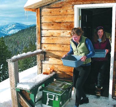 
Ramsey Larson, left, and Taylor Yost of Spokane do kitchen chores during their stay at the scenic Rendezvous Hut, a wood-heated backcountry cabin reached by skiing six miles on the Methow Valley Sports Trails Association's groomed trail system. 
 (Photos by RICH LANDERS / The Spokesman-Review)