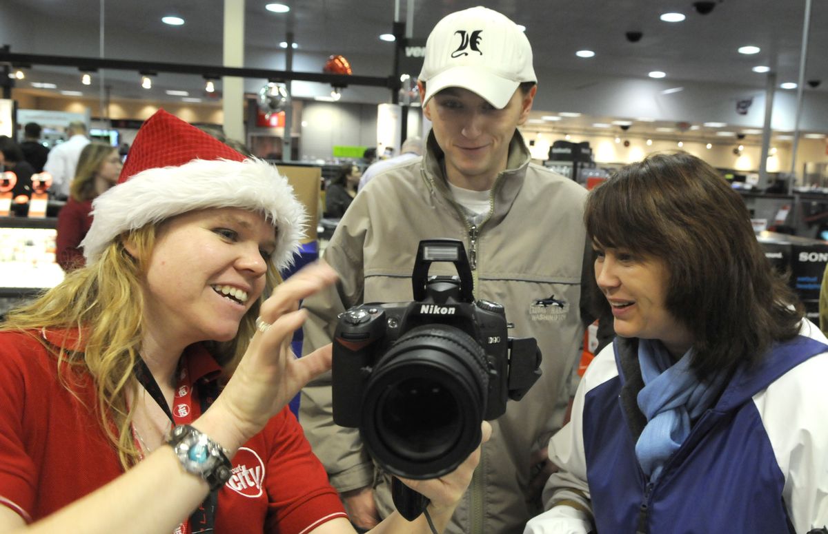 Saleswoman Katie LaFountain demonstrates the workings of a digital camera  to Colleen Boucher  and her son Chad on Friday morning at the Circuit City in Spokane Valley. (Colin Mulvany / The Spokesman-Review)