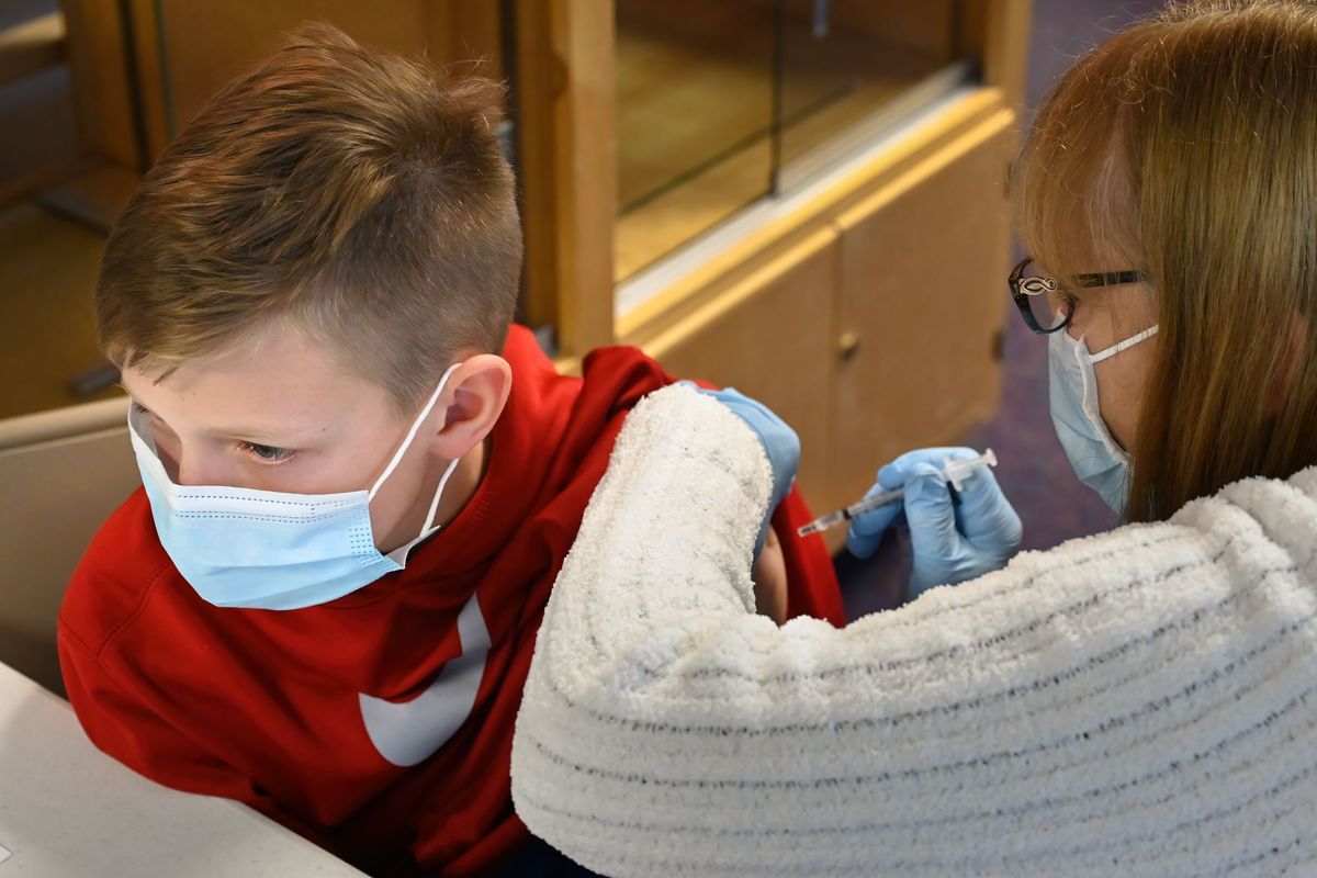 Lincoln Slatter, 10, receives his COVID-19 vaccine shot from volunteer Kathy Morgan R.N at the first major in-school COVID vaccination clinic for kids aged 5-11, Wednesday, Nov. 17, 2020, at Trent Elementary School. The Washington Board of Health on Wednesday voted to not require the COVID-19 vaccination for schools and day cares.  (COLIN MULVANY/THE SPOKESMAN-REVIEW)
