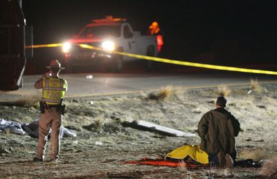 Officials investigate the scene of a tour bus crash on U.S. Highway 93 near Dolan Springs, Ariz., on Friday. Seven passengers were killed and at least 10 other people injured.  (Associated Press / The Spokesman-Review)