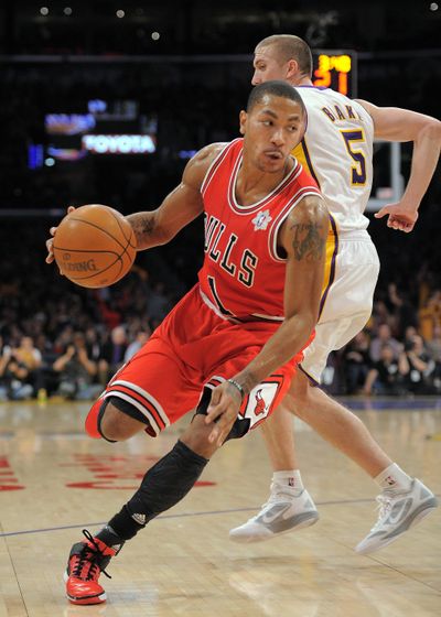 Bulls’ Derrick Rose dribbles past Lakers’ Steve Blake. (Associated Press)