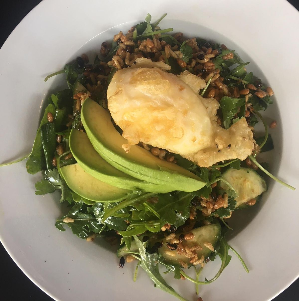 The crispy rice salad at Honey Eatery features avocado and a poached fried egg. (Adriana Janovich / The Spokesman-Review)