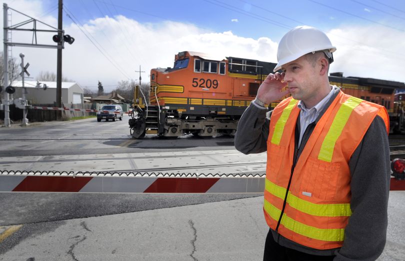 Spokane Valley project manager Ken Knutson plugs an ear against a BNSF freight train horn blast at Park Road south of Trent Avenue. Knutson said the state is kicking in money to fix the crossing so motorists won’t be able to drive around lowered crossing arms. (Colin Mulvany)