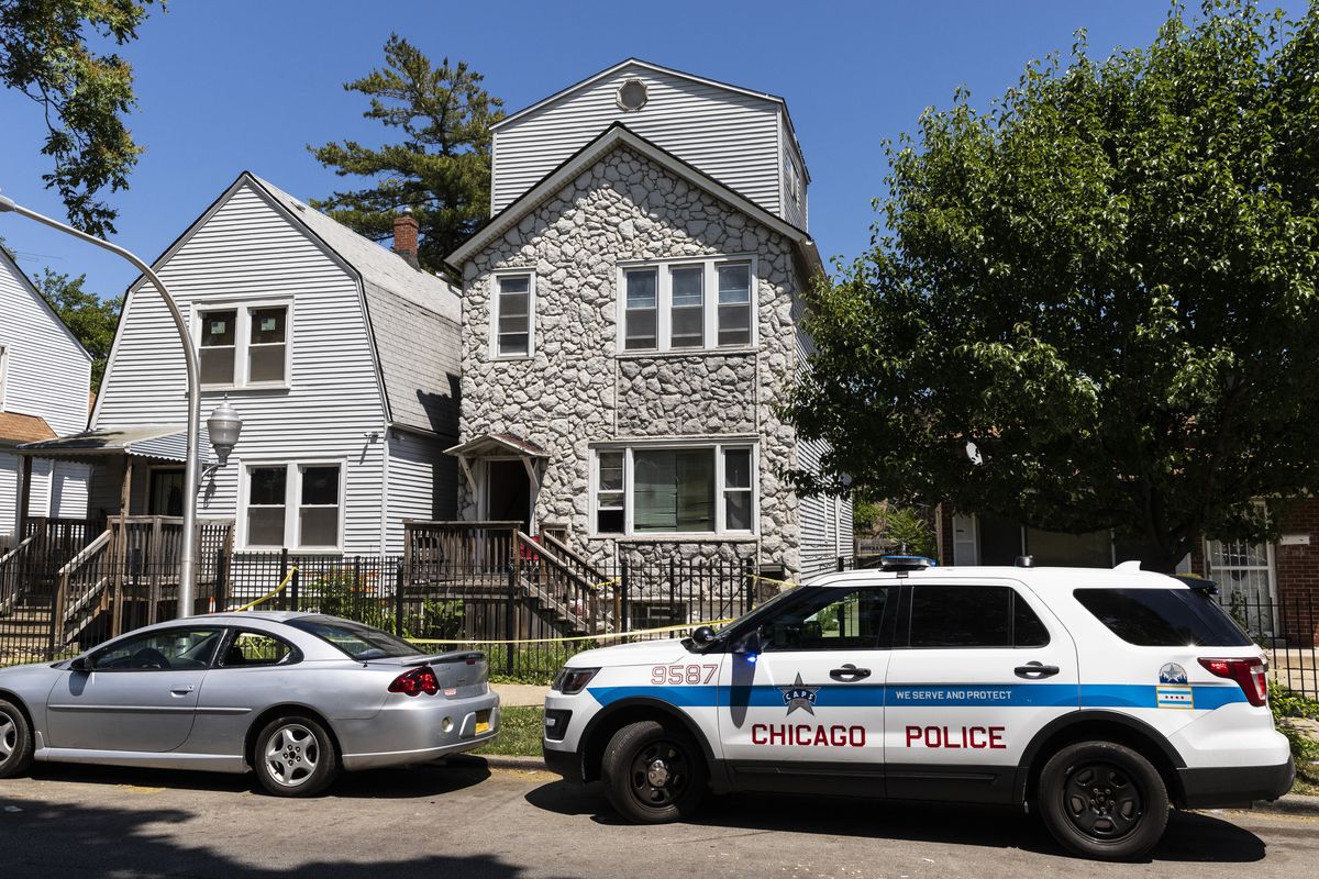 Chicago police keep watch and crime scene tape hangs outside a house in the 6200 block of South Morgan, where multiple people were shot, some fatally, inside the Englewood building, Tuesday afternoon, June 15, 2021, in Chicago. An argument in the house on Chicago