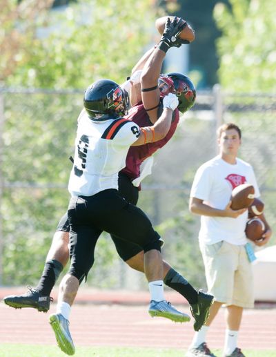 Whitworth’s Anthony Fullman hauls in a pass over Lewis & Clark’s Chris Shirey. (TYLER TJOMSLAND PHOTOS)