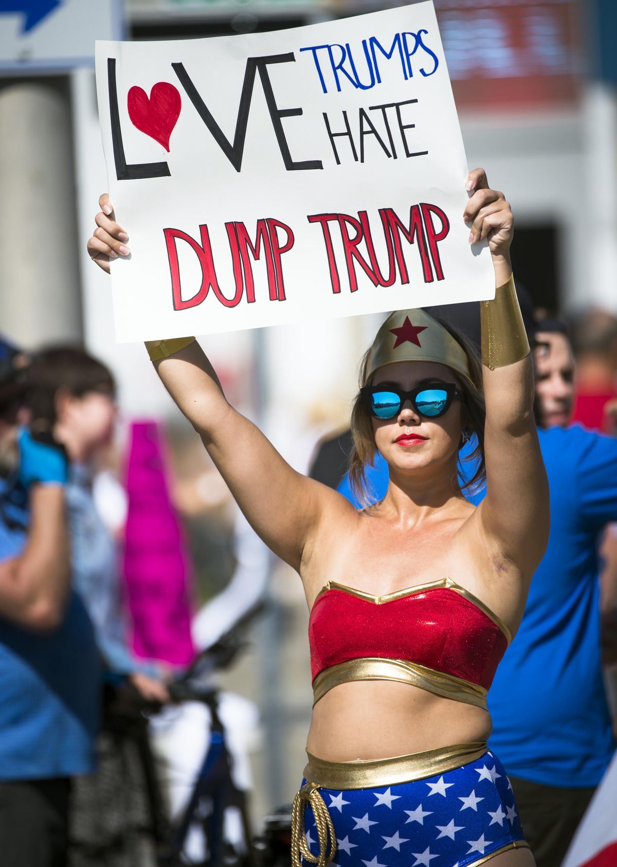 Wonder Woman (Cam Zorrozua) holds up a sign outside the Donald Trump rally at the Spokane Convention Center in Spokane, May 7, 2016. (Colin Mulvany / The Spokesman-Review)
