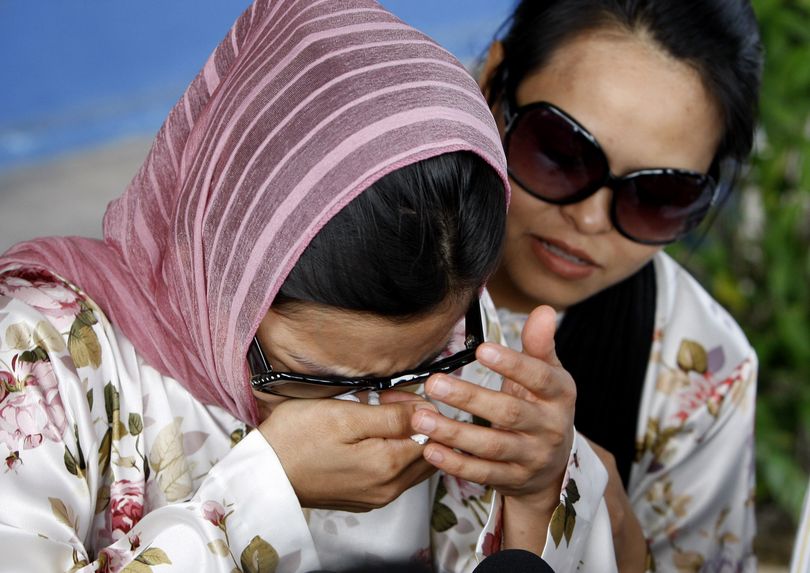 ORG XMIT: XMB113 Muslim model Kartika Sari Dewi Shukarno, 32, left, who was to caned for drinking beer, is comforted by her sister Ratna as she talks to waiting media outside the Kuala Kangsar police station, Malaysia, Monday, Aug. 24, 2009. Islamic officials Monday abruptly released the model scheduled to be caned this week for drinking beer after briefly detaining her, in an unexpected twist for Malaysia's first woman to face the corporal punishment. (AP Photo/Mark Baker) (Mark Baker / The Spokesman-Review)