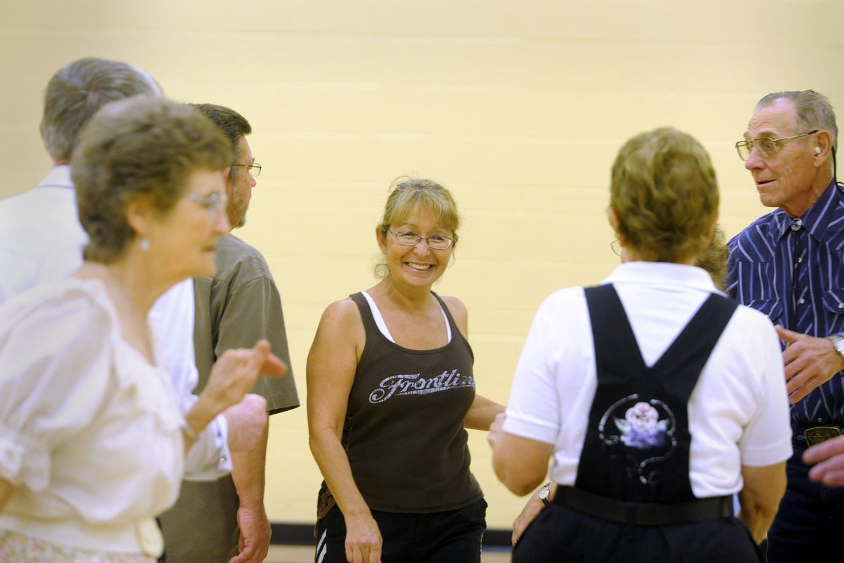 Anna Van Antwerp, center, smiles as she loses her place  during her first square dance  experience  at Peak Fitness. (The Spokesman-Review)
