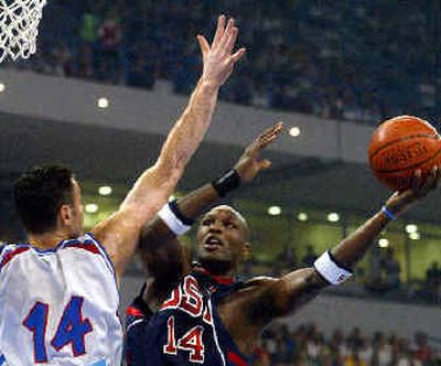 
Team USA's Lamar Odom, right, drives to the basket as Dejan Tomasevic, left, of Serbia-Montenegro, defends during their exhibition game Friday.
 (Associated Press / The Spokesman-Review)