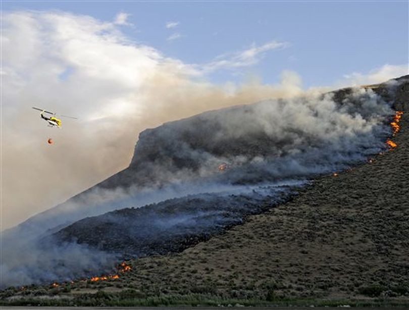 Emergency responders carry water to dump on wildfires Saturday, June 6, 2015, near Celebration Park south of Melba, Idaho.  (AP/Idaho Press-Tribune / Adam Eschbach)