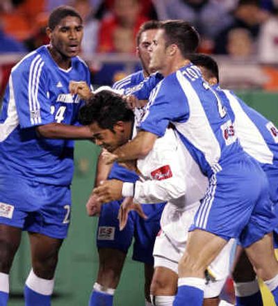 
Kansas City Wizards defenseman Alex Zotinca, right, roughs up Los Angeles Galaxy's Carlos Ruiz in the Western Conference final Friday.
 (Associated Press / The Spokesman-Review)