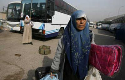 
An Iraqi refugee that has just returned from Syria removes her luggage from a bus Nov. 29 in Baghdad. The Iraqi government is touting refugees' return as a sign of growing public confidence.  Associated Press
 (File Associated Press / The Spokesman-Review)