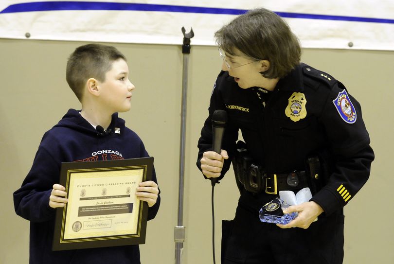 Jason Graham holds the Citizen Lifesaving Award he received from Spokane Police Chief Anne Kirkpatrick during a ceremony Thursday,  March 25, 2010, at Roosevelt Elementary School, in his honor. Jason helped rescue his mother from under the family van. (Dan Pelle / The Spokesman-Review)