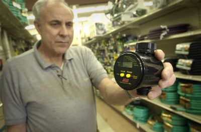 
Coeur d'Alene Ace Hardware owner John Montandon holds a hose bib timer,  which can turn water on and off for lawn sprinkling. The device can qualify Coeur d'Alene residents for $75 utility bill credits. 
 (Jesse Tinsley / The Spokesman-Review)