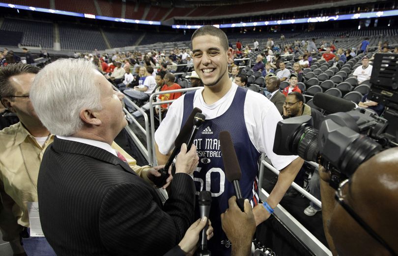 Saint Mary's Omar Samhan smiles as he is surrounded by reporters during an NCAA college basketball practice in Houston, Thursday, March 25, 2010. Saint Mary's will play Baylor in a South Regional semifinal on Friday. (David Phillip / Associated Press)
