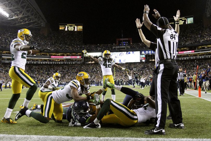 One official signals touchdown, while another waves it off, but Golden Tate’s “Fail Mary” catch stood. (Associated Press)