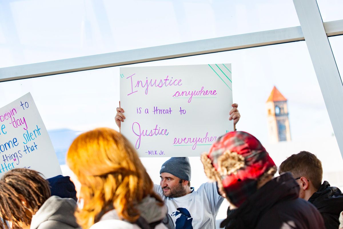 Joseph Martin holds up a sign while crowds exit the Spokane Convention Center for the Martin Luther King Jr. march on Monday, Jan. 21, 2019. The march was preceded with an event there that had an estimated 3,000 people in attendance. (Libby Kamrowski / The Spokesman-Review)
