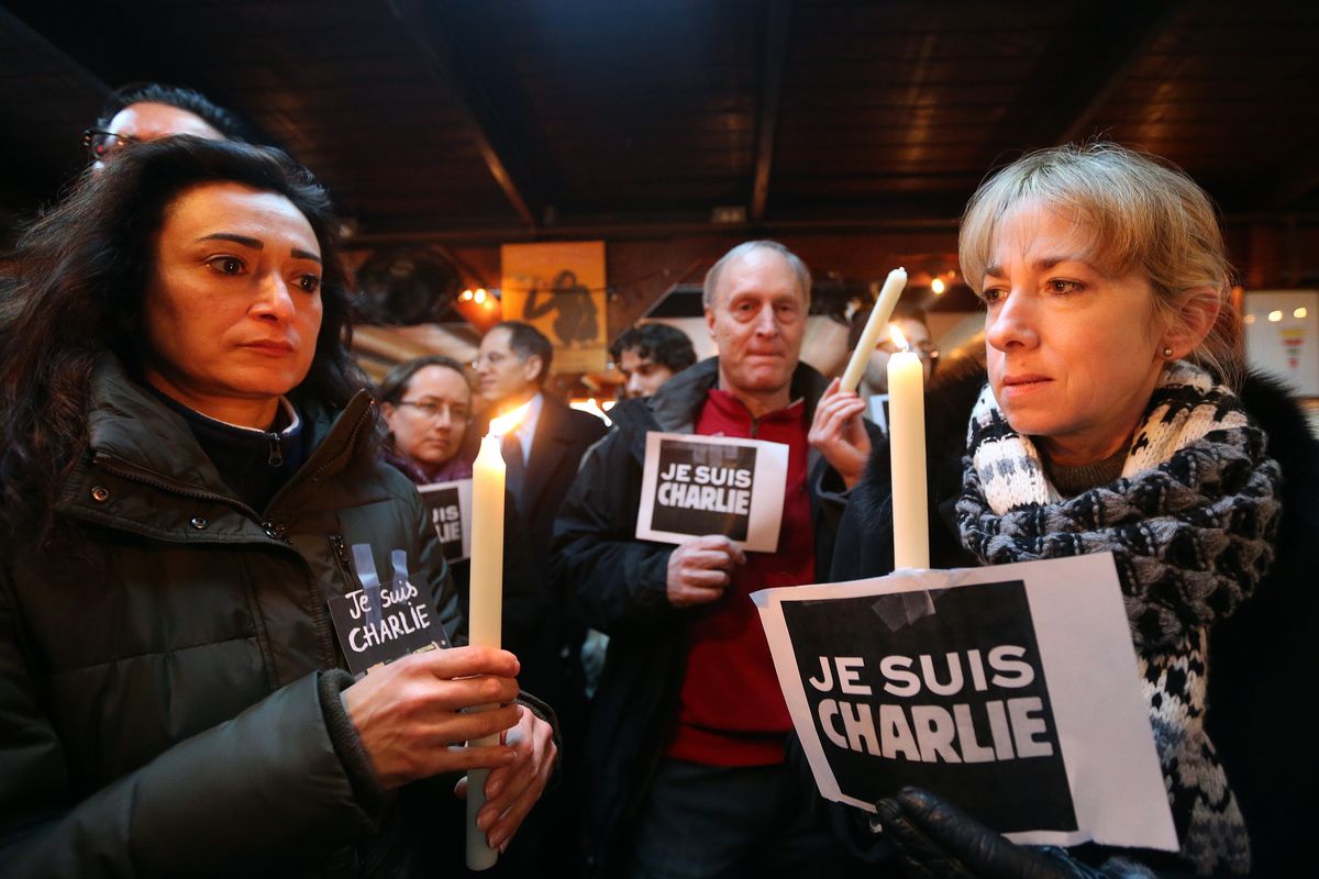 Mojgan Zarrabi, left, and Ken and Tami Brook participate in a gathering at Anis Bistro on Thursday to show support for France following the terror attack at the satirical newspaper Charlie Hebdo. (Associated Press)