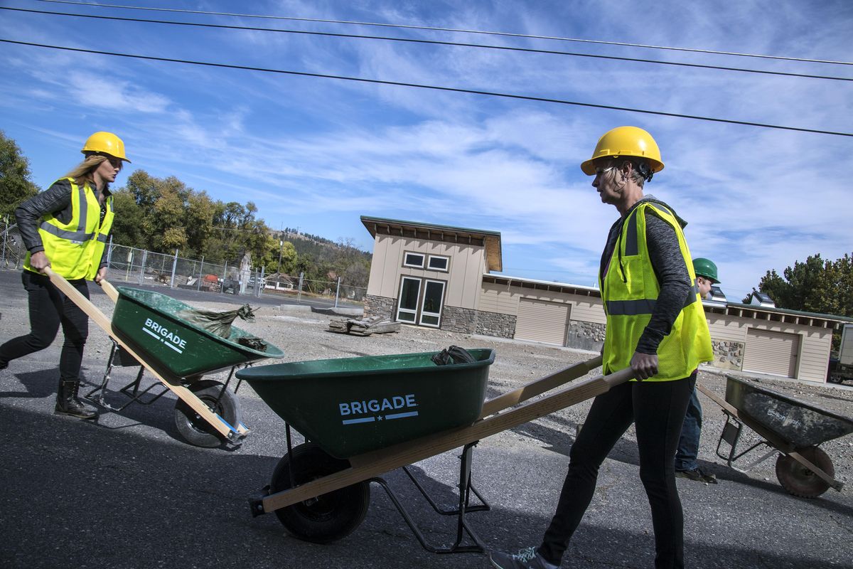 Joey Hamilton, left, and Shannon Caruso, students in the Spokane Community College Apprenticeship Training Center, compete in a wheelbarrow relay race, as part of their class, Sept. 21, 2016. The wheelbarrows held two sacks weighing 20 pounds each. (Dan Pelle / The Spokesman-Review)