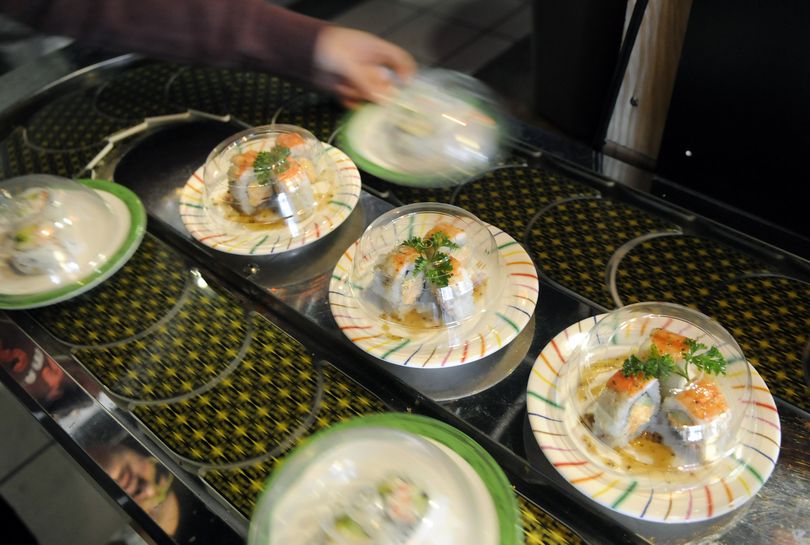 Plates of sushi are added to a conveyor belt for customers to choose from at the Sushi Track.