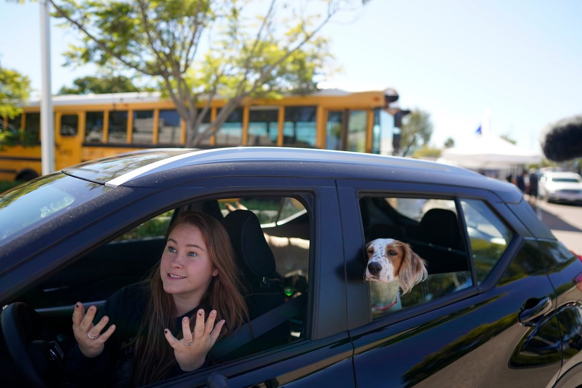Brooklyn Pittman talks as she sits in her car with her dogs after receiving food from an Armed Services YMCA food distribution, Oct. 28, 2021, in San Diego. As many of 160,000 active duty military members are having trouble feeding their families, according to Feeding America, which coordinates the work of more than 200 food banks around the country.  (Gregory Bull)