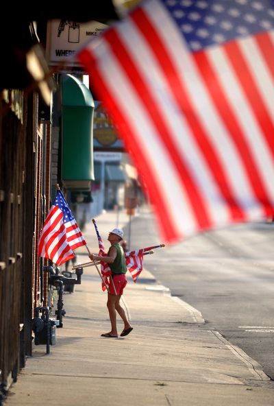 Flag Day duty: Reid Woodbury places flags along Frederick Avenue in midtown St. Joseph, Mo., Thursday in honor of Flag Day. (Associated Press)