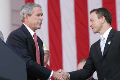 
President Bush greets the master of ceremonies, actor Gary Sinise, during a Veterans Days ceremony at Arlington National Cemetery in Arlington, Va., on Saturday. 
 (Associated Press / The Spokesman-Review)