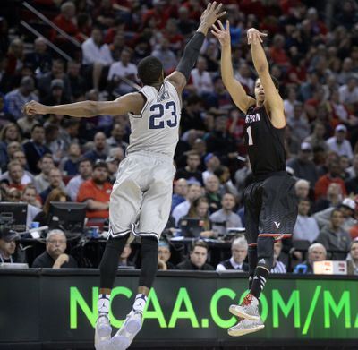 Eastern Washington University 's Tyler Harvey fires a 3-point shot over Georgetown's Aaron Bowen  during their 2015 NCAA Men's Basketball championship second round game against Georgetown, March 19, 2015, in Portland, Ore. (The Spokesman-Review)