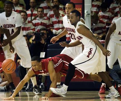 Arizona's Derrick Williams (23) and Nic Wise, right, watch Washington State's Reggie Moore, bottom, dive for a loose ball in the second half of an NCAA college basketball game at McKale Center in Tucson, Ariz., Friday, Jan. 8, 2010. Washington State won, 78-76. (Wily Low / Fr53753 Ap)