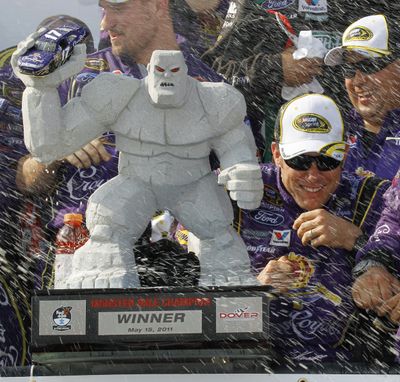 Matt Kenseth (to right of trophy) hides from the spray as he and his crew celebrate in Victory Lane. (Associated Press)