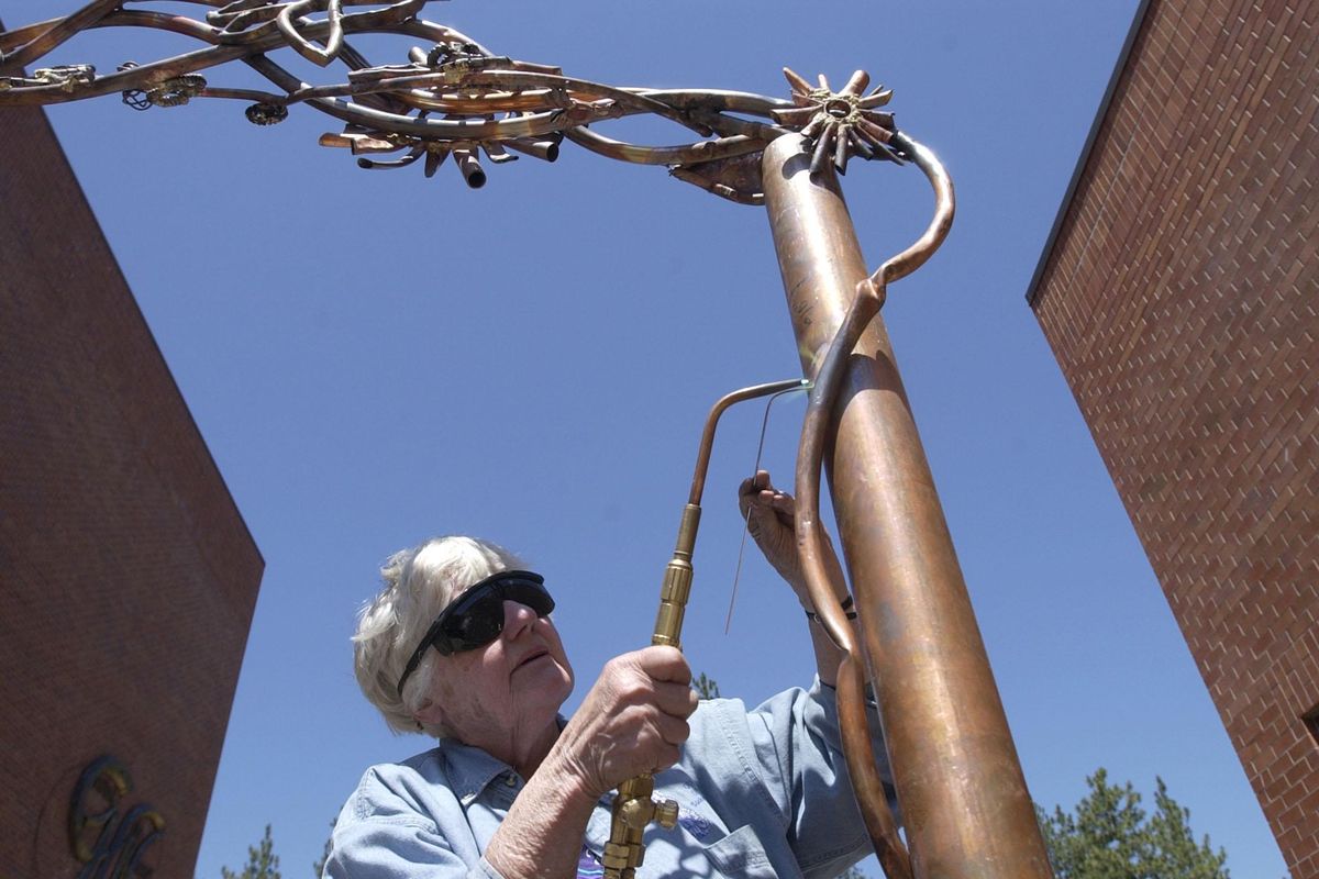 Sister Paula Turnbull welds a copper vine to an entrance gate to the Blessed Marie-Rose Garden of Life at the Convent of Holy Names. (Dan Pelle / The Spokesman-Review)