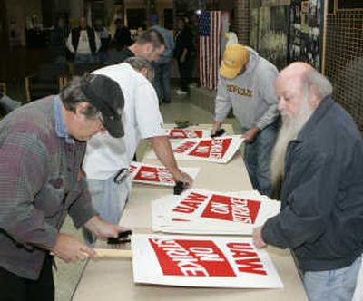 
United Auto Workers members Mike Freeman, left, who has worked at General Motors Corp. for 35 years, and Roger Kendrick, right, who has also worked at GM for 35 years, prepare picket signs in case of a strike at UAW Local 599 in Flint, Mich., on Friday. Associated Press
 (Associated Press / The Spokesman-Review)