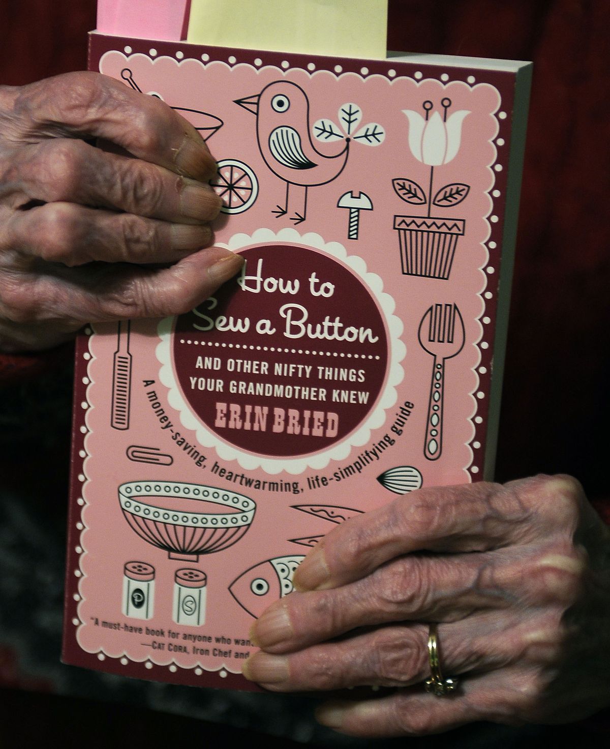 Jean Dinsmore, who grew up on a farm in Troy, Idaho, holds the book, “How to Sew a Button – and Other Nifty Things Your Grandmother Knew.” Dinsmore, one of 10 grandmothers interviewed from around the country for the book, says she learned how to cook, clean, do laundry, sew and knit from her own mother.