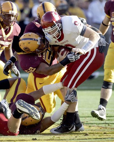 WSU quarterback Kevin Lopina is tackled by Arizona State’s Morris Wooten.  (Associated Press / The Spokesman-Review)