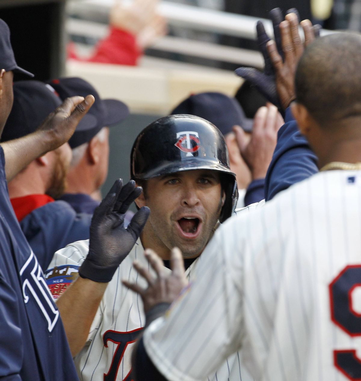 Twins’ Brian Dozier is congratulated in the dugout after hitting three-run homer. (Associated Press)