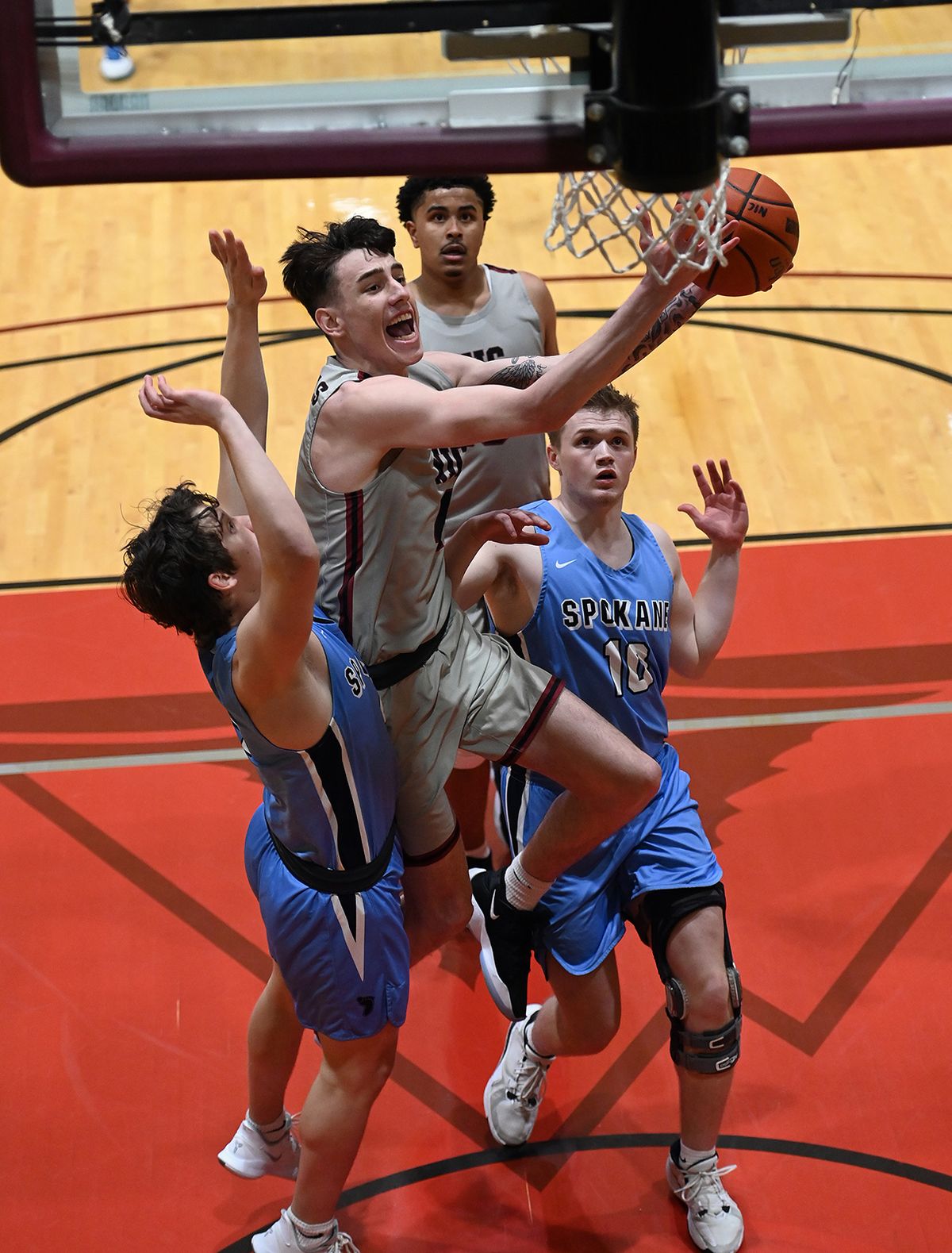 North Idaho College guard Cooper DeWit heads for a layup as Community Colleges of Spokane guard Paul Terry on left, defends in the first half of a college basketball game, Tuesday, April 13, 2021, at North Idaho College.  (Colin Mulvany/THE SPOKESMAN-REVIEW)