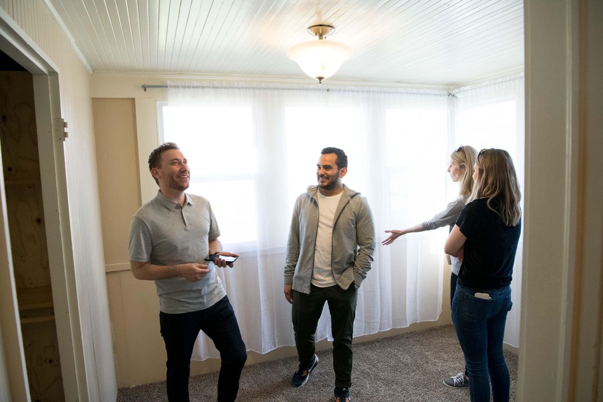 Real estate Agent Patrick Kendrick, left, smiles as he does a final walk through on a home with Diego Sanchez, center, and Amy Sanchez, right, and her mother, Melissa Juran, on Monday April 23, 2018, in Spokane. (Tyler Tjomsland / The Spokesman-Review)