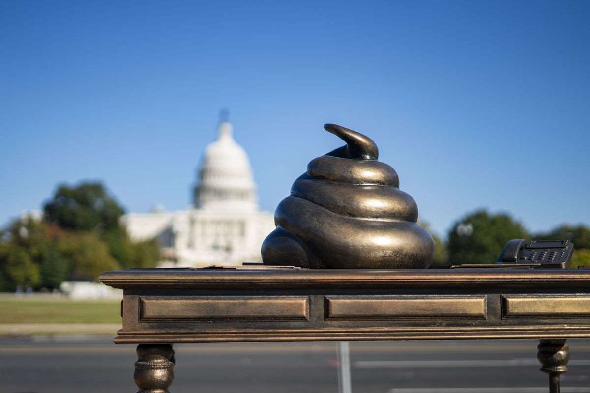 A new installation on the National Mall features a bronze poop atop a desk with a rendering of an office phone and nameplate belonging to Rep. Nancy Pelosi (D-Calif.). The memorial “honors” those who participated in the Jan. 6 riot. (MUST CREDIT: Allison Robbert for The Washington Post)  (Allison Robbert/For The Washington Post)