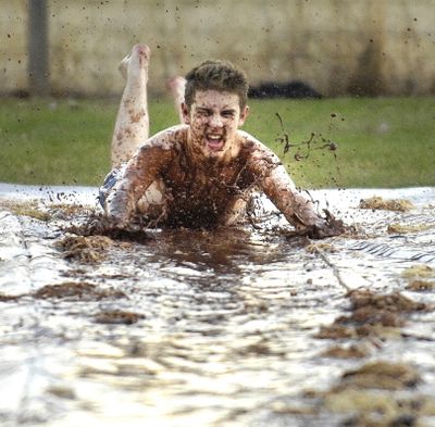 ORG XMIT: IDLEW101 Chocolate flies as Kelcy Mastrup dives onto a slip-n-slide covered with chocolate pudding, ice cream, noodles and water during Warner Alliance Church's junior high kids outreach event, Wednesday, Nov., 4, 2009, in Lewiston, Idaho. (AP Photo/Lewiston Tribune, Kyle Mills) (Kyle Mills / The Spokesman-Review)