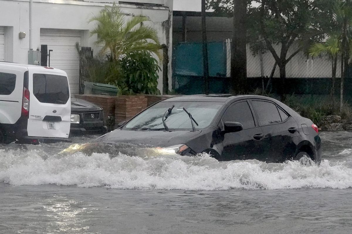A car makes its way through a flooded street in Oakland Park, Fla., on Wednesday.  (Joe Cavaretta/Sun Sentinel/TNS)
