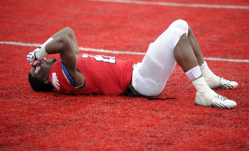 Eastern Washington Eagles running back Quincy Forte (22) lays on the red turf after his Eagle football team fell to Towson 35-31, Saturday, Dec. 21, 2013, at Roos Field in Cheney, Wash. (Colin Mulvany / The Spokesman-Review)