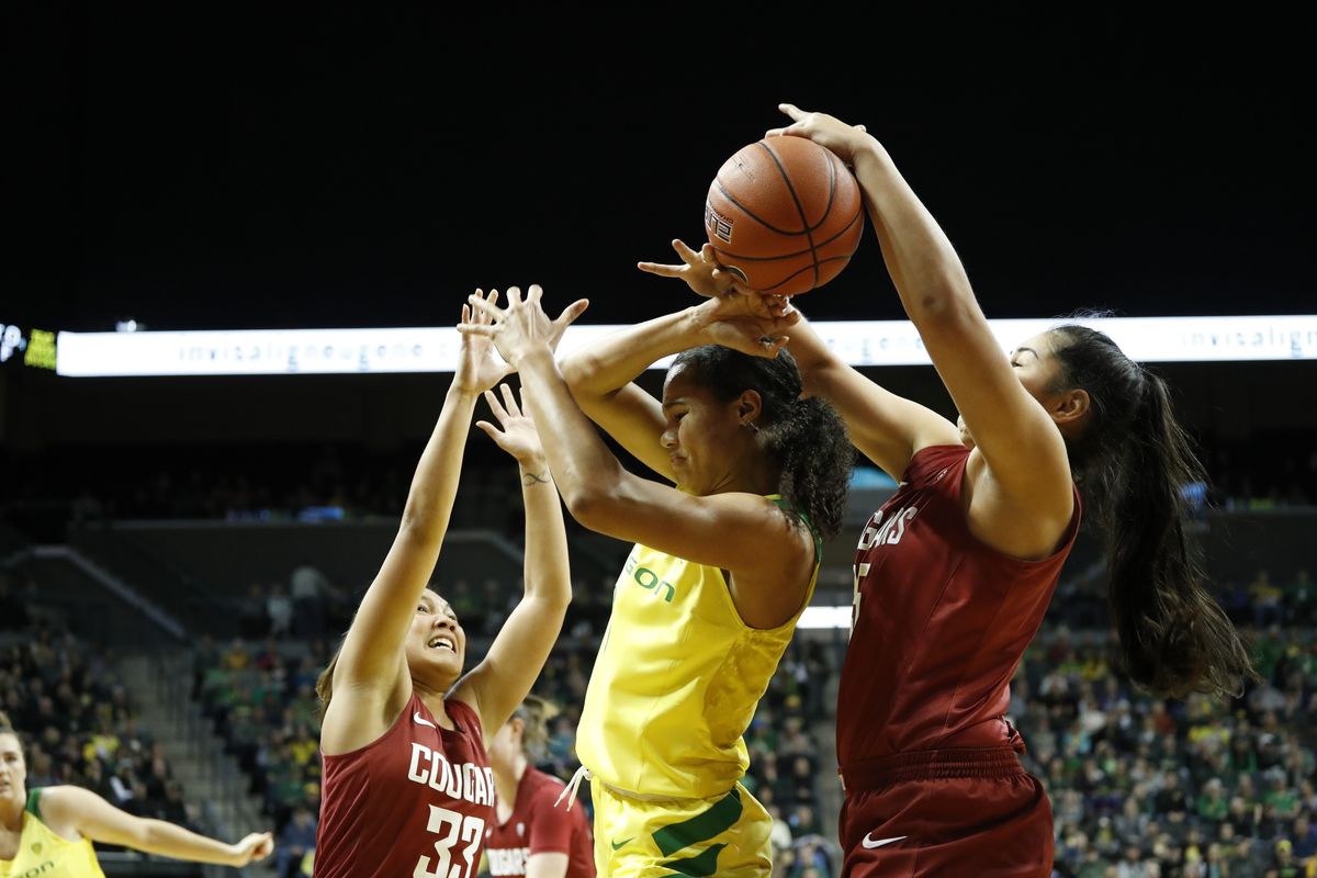 Oregon forward Satou Sabally fights for the ball against Washington State forward Ula Motuga, right, and Cherilyn Molina, left, during an NCAA college basketball game Sunday, Jan. 6, 2019, in Eugene, Ore.  (Associated Press)
