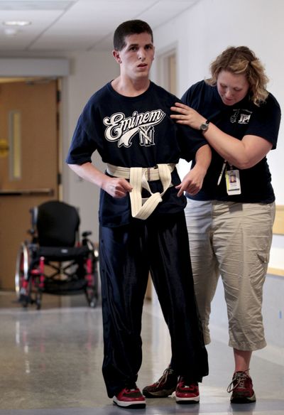 Zack Lystedt leaves behind his wheelchair and walks with physical therapist Whitney Thomas’ assistance. (Associated Press)
