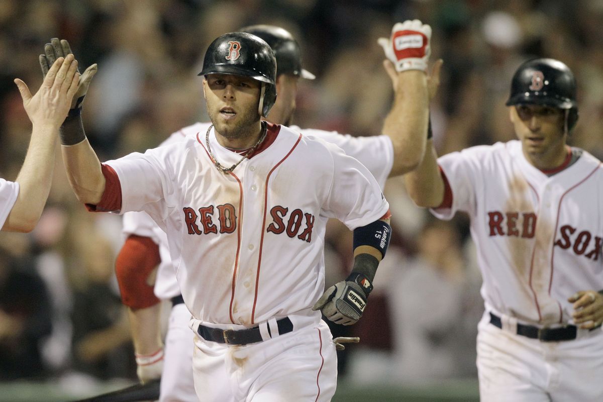 Boston’s Dustin Pedroia is congratulated after hitting a two-run home run that drove in Marco Scutaro, right, in the seventh. (Associated Press)