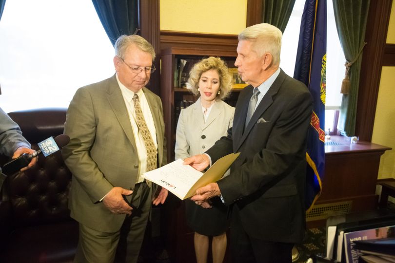 David Leroy, right, submits a letter of intent to Idaho Secretary of State Lawerence Denney, left, to run for the 1st District congressional seat in 2018; at center is Leroy's wife Nancy. (Otto Kitsinger)